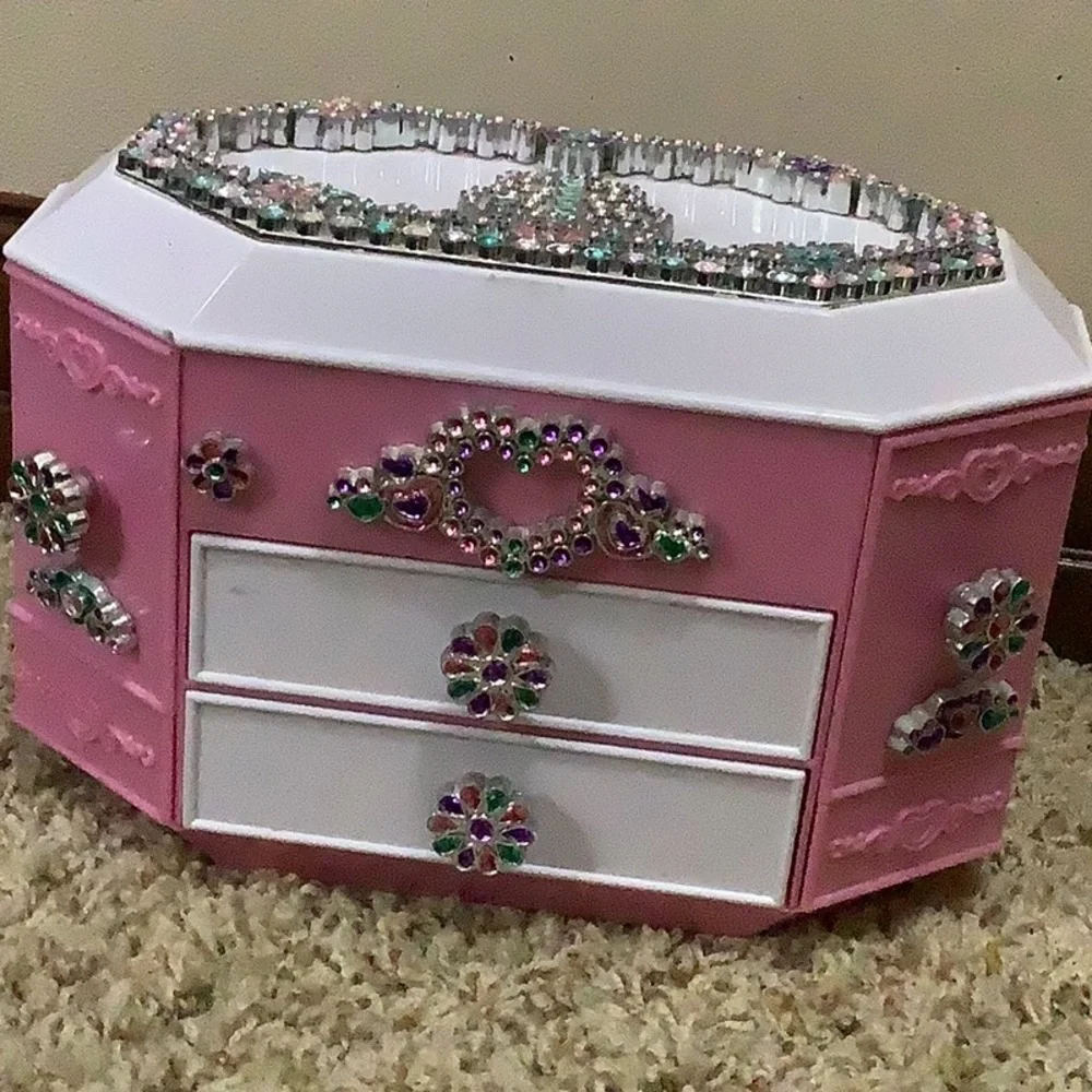 I am selling a pink jewelry box with stones with drawers with side openings